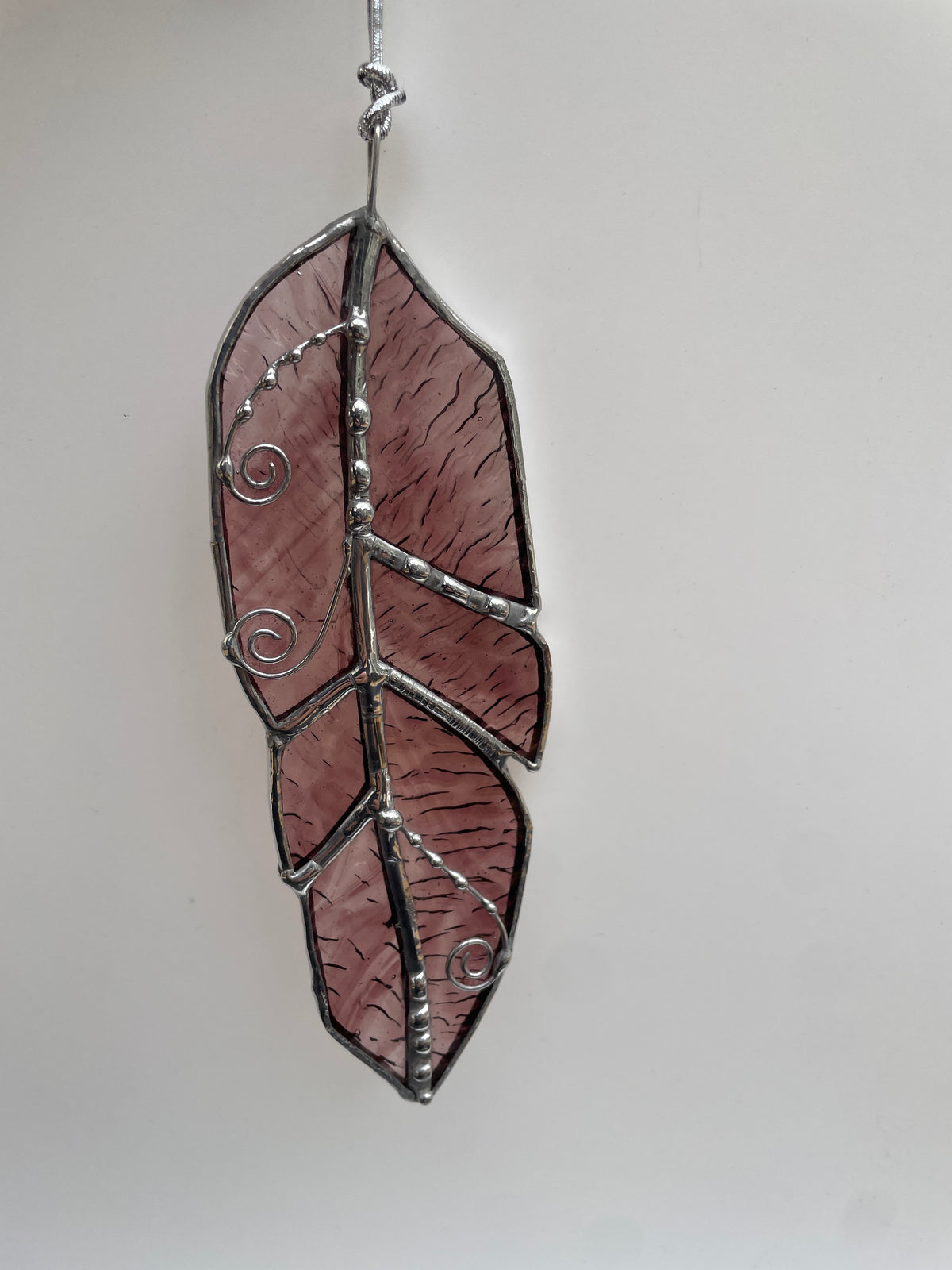 Clear stained glass feather with purple granite glass and decorative solder detail