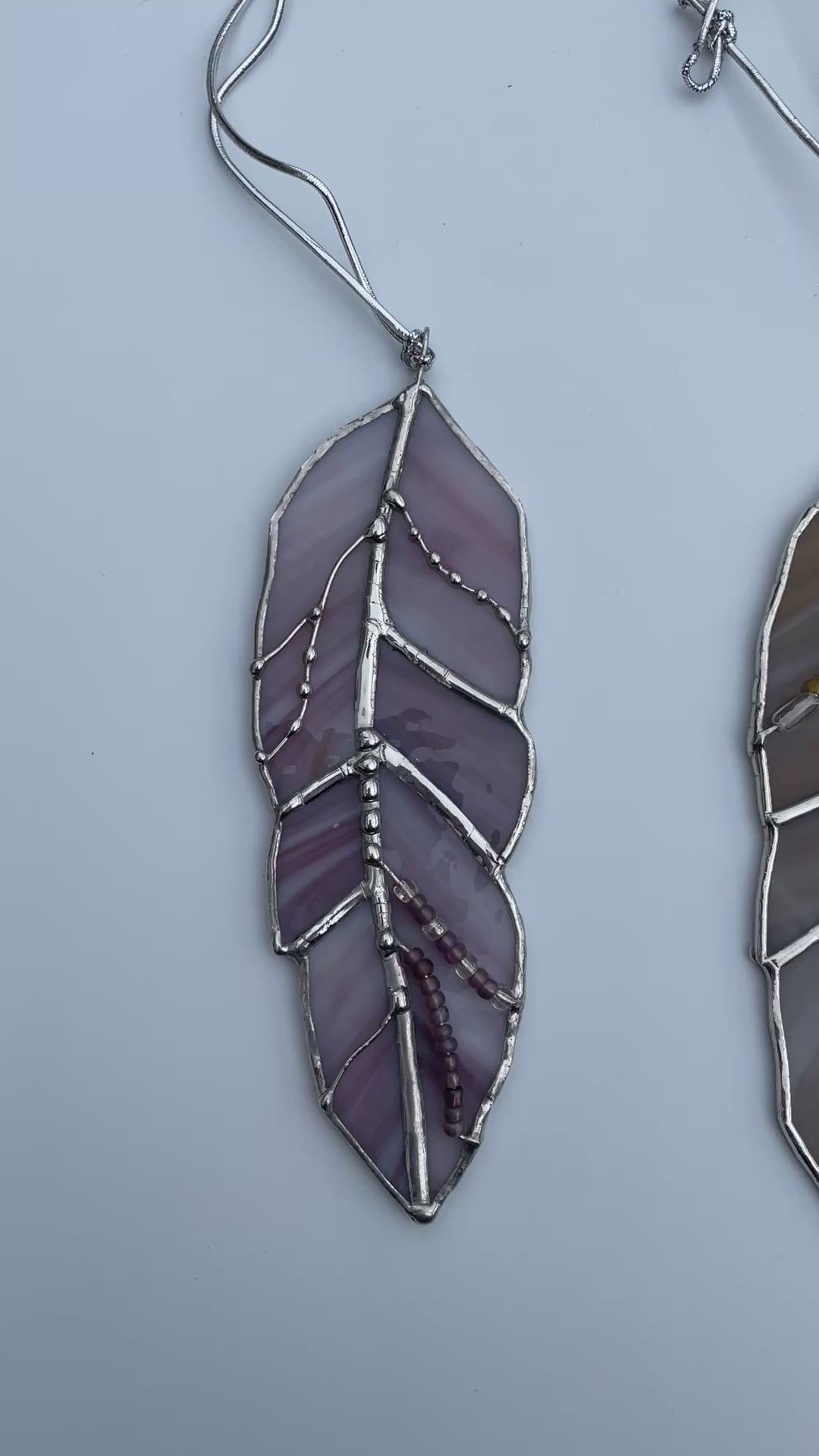Collection of handcrafted stained glass feathers in purple, amber, bronze, blue and clear art glass